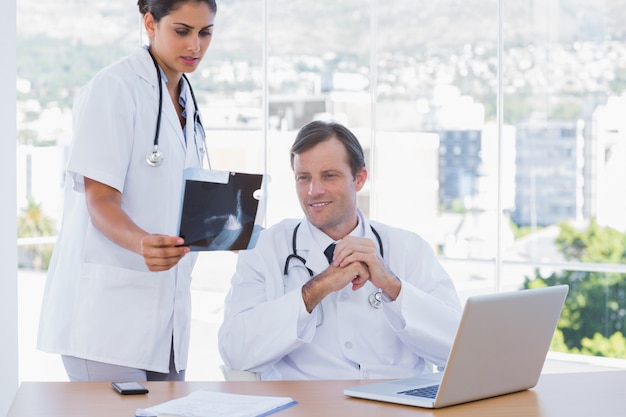 Pretty doctor showing a x ray to a colleague