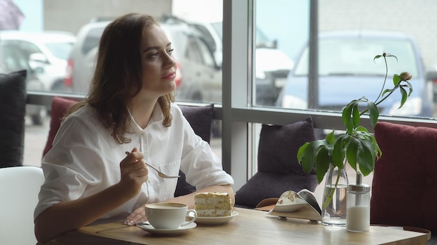 Pretty drinking coffee in a cafe young woman in business clothes on a lunch break