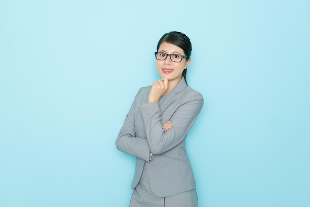 pretty elegant office worker lady in blue background and face to camera smiling.