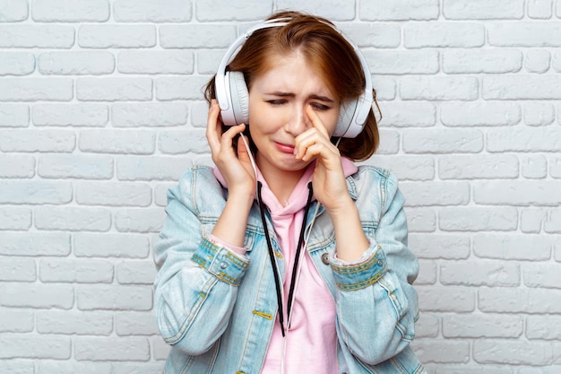 Pretty fashion cool girl listening to music in headphones