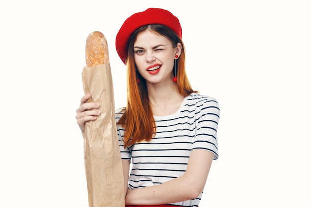 Pretty french woman holding a loaf of striped tshirt light background