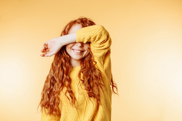 Pretty ginger young woman closing her eyes with hands