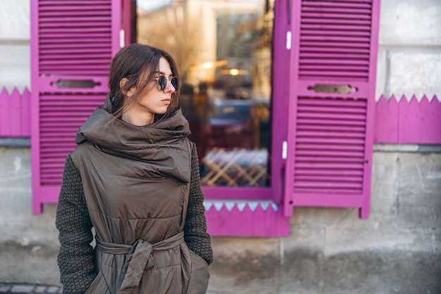 Photo pretty girl in coat sunglasses walking outdoor.