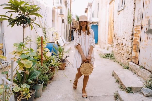 Pretty Girl in a Dress and Hat Walks the Old Streets