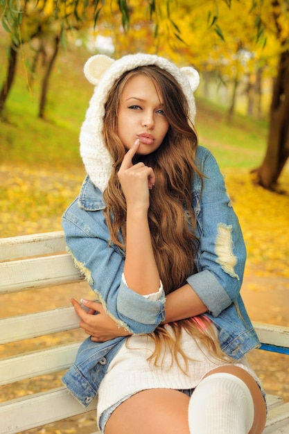 Photo pretty girl in a knitted bear hat.