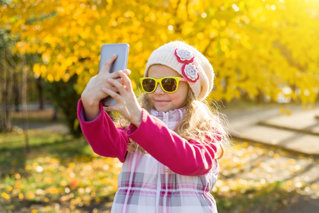 Pretty girl of seven years doing selfie using smartphone