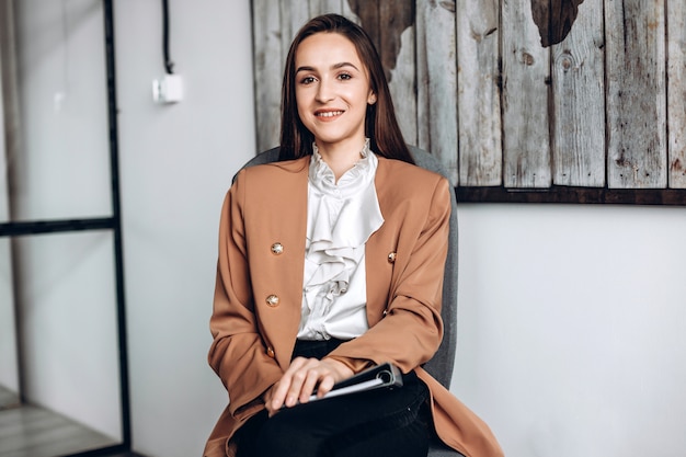 Pretty girl sitting in a chair, working in the office