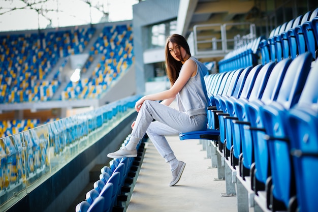 Pretty girl sitting at school stadium.