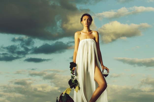 Pretty girl with wine bottle over sky