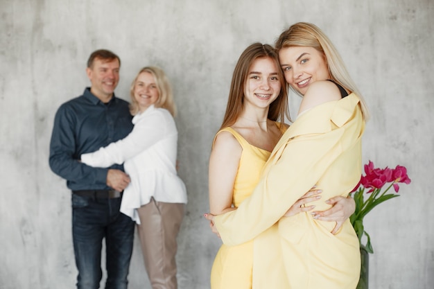 Pretty girls embracing and parents hugging blurred behind. 