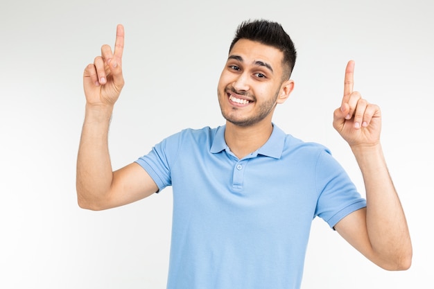 Pretty guy in a blue t-shirt with holding hands on a white studio background