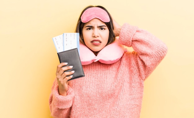 Pretty hispanic girl feeling stressed anxious or scared with hands on head flight passenger concept