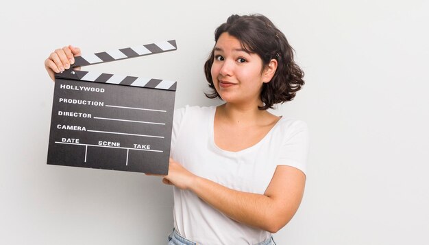 Pretty hispanic girl shrugging feeling confused and uncertain cinema concept