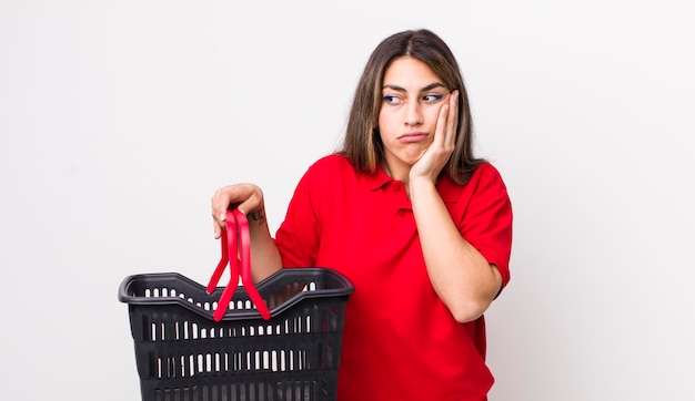 Pretty hispanic woman feeling bored frustrated and sleepy after a tiresome empty shopping basket concept