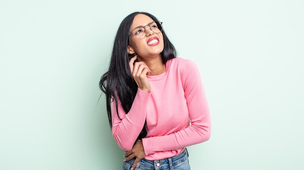 Pretty hispanic woman feeling stressed, frustrated and tired, rubbing painful neck, with a worried, troubled look