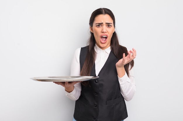 Pretty hispanic woman looking desperate frustrated and stressed waiter with tray concept