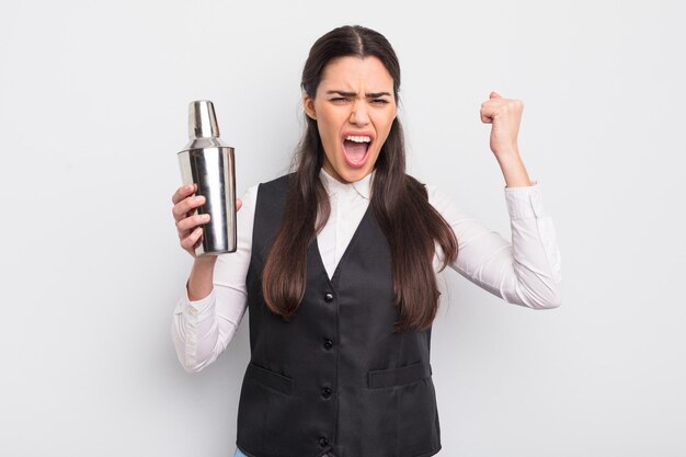 Pretty hispanic woman shouting aggressively with an angry expression barman cocktail concept