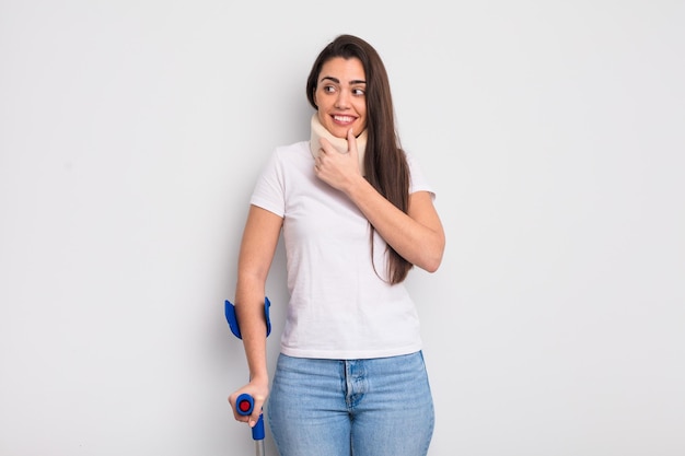 Pretty hispanic woman smiling with a happy confident expression with hand on chin crash and physical injury concept