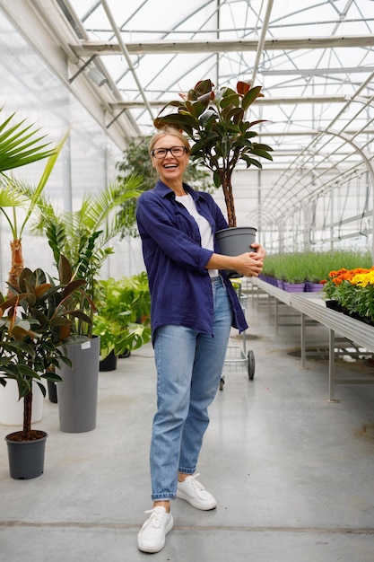 Pretty lady buying ornamental plants at a flower greenhouse