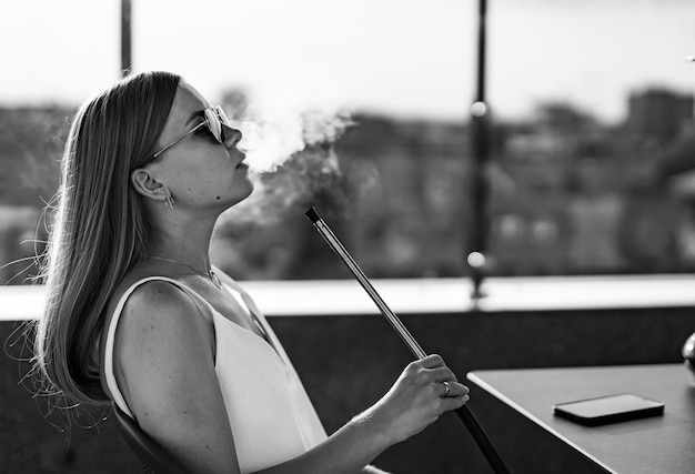 Pretty lady smoking hookah Beautiful lifestyle person smokes tobacco