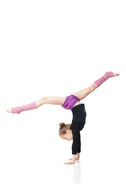 Pretty little girl doing gymnastics over white background