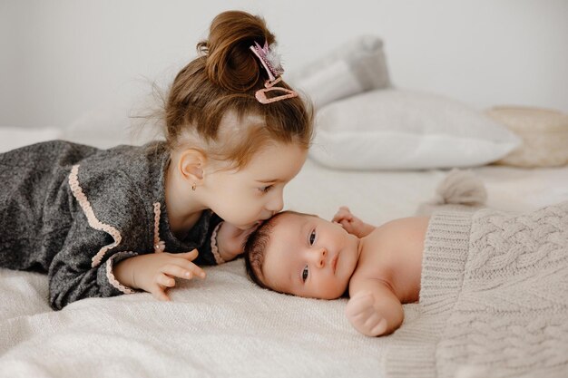 pretty little girl kissing her adorable baby brother