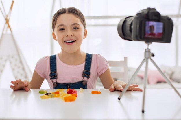 Pretty little girl taking with her audience in front of the camera