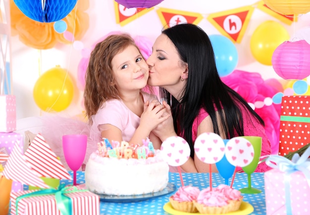 Pretty little girl with mom celebrate her birthday