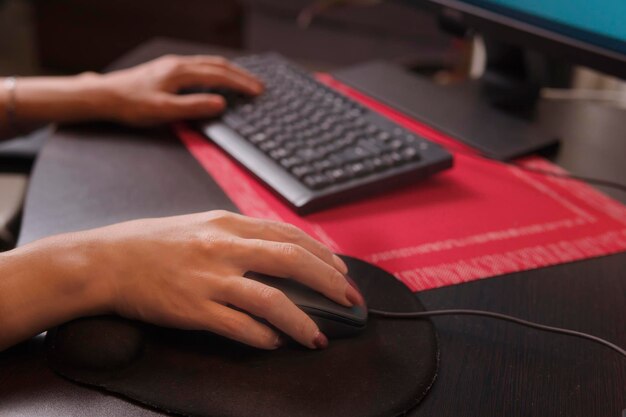 Pretty middle aged latin woman using mouse in her work area