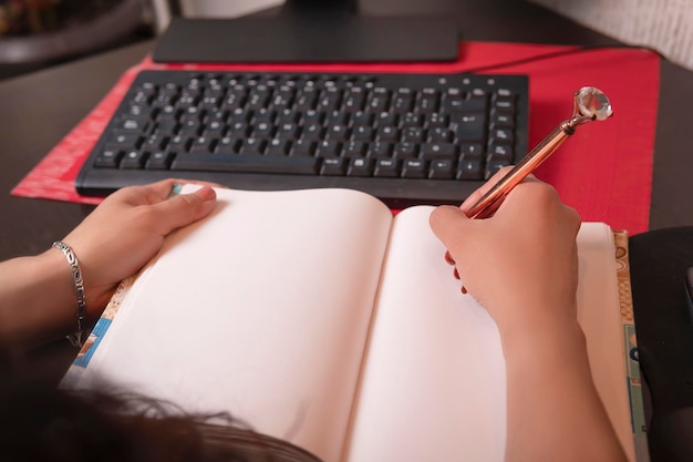 Pretty middleaged latin woman writing in her workspace