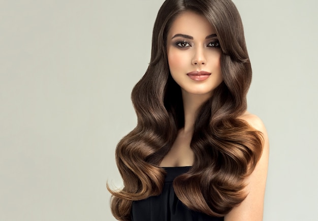 Pretty model with long curly well groomed hair Excellent hair waves Hairdressing art and hair care