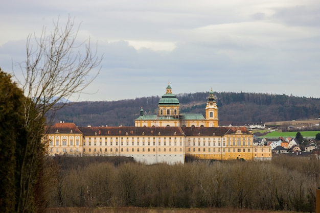 Pretty monastery among the autumn trees and a field of cultivation. Melk Abbey.