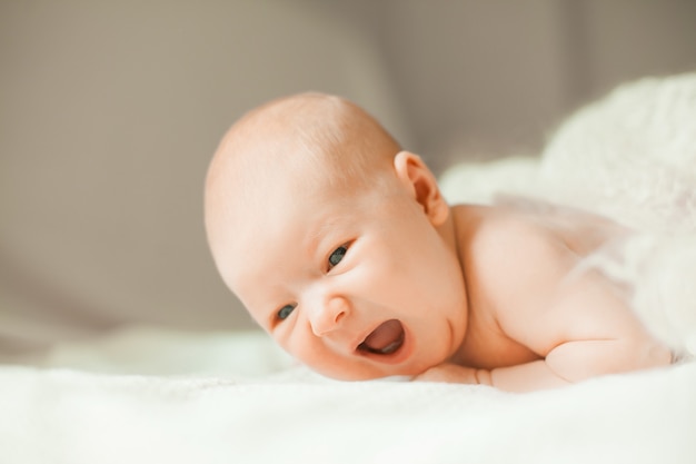 Pretty newborn girl lying on her tummy on a blanket.