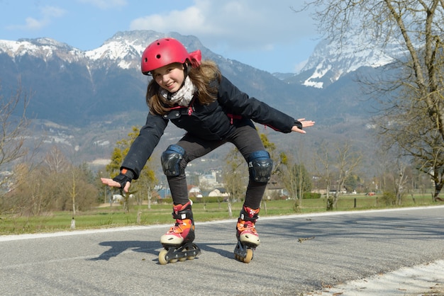 pretty preteen girl on roller skates in helmet at a track