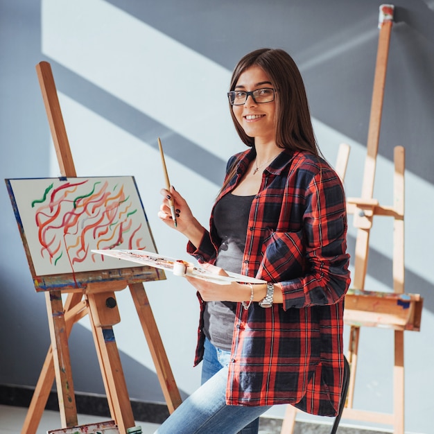 Pretty Pretty Girl artist paints on canvas painting on the easel.