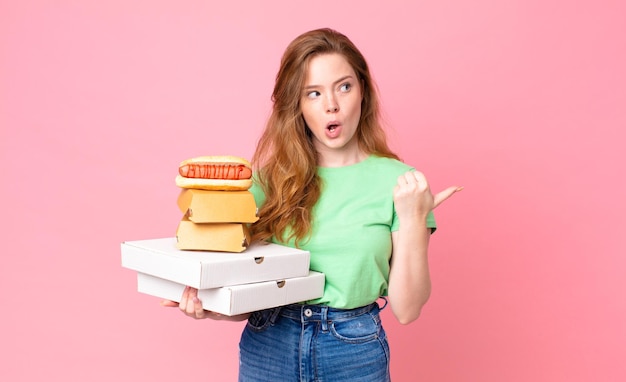 Pretty red head woman holding take away fast food boxes