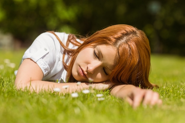 Pretty redhead napping on grass