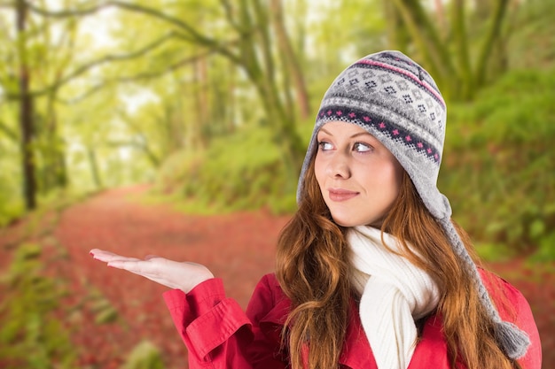 Pretty redhead in warm clothing against peaceful autumn scene in forest