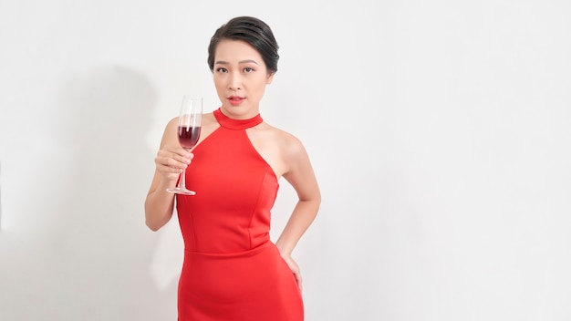 Pretty sexy woman on white background. Beautiful young lady in evening dress looking. Glass of champagne in hand.