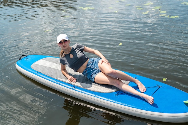 Pretty slim woman relax on sup board in summer time sea adventure freedom