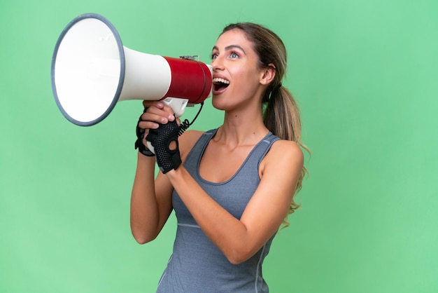 Pretty Sport Uruguayan woman over isolated background shouting through a megaphone