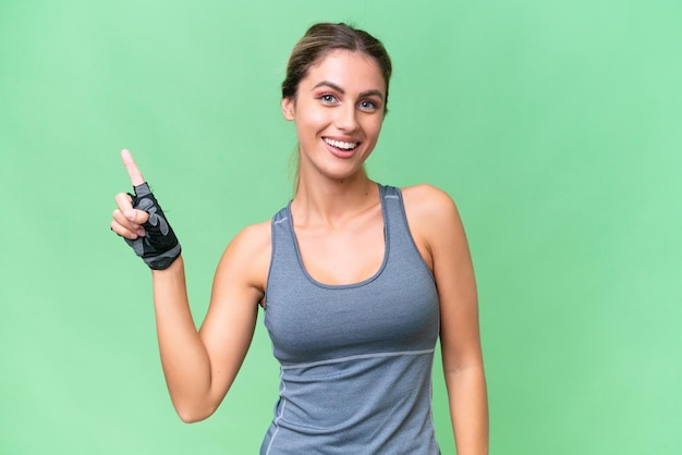 Pretty Sport Uruguayan woman over isolated background showing and lifting a finger in sign of the best