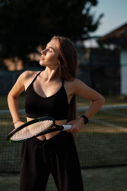 Pretty sportswoman with racquet at the tennis court Healthy lifestyle