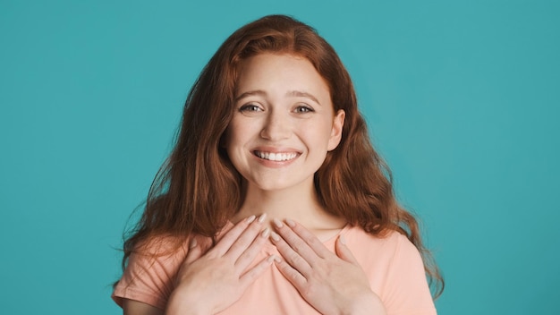 Pretty surprised redhead girl joyfully looking in camera and smiling over colorful background Excited expression