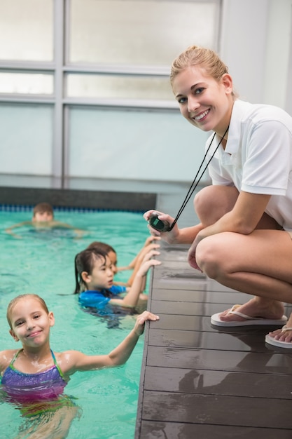 Photo pretty swimming coach smiling at camera at the leisure center