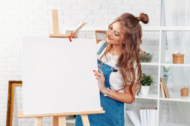 Pretty talented female painter painting on easel