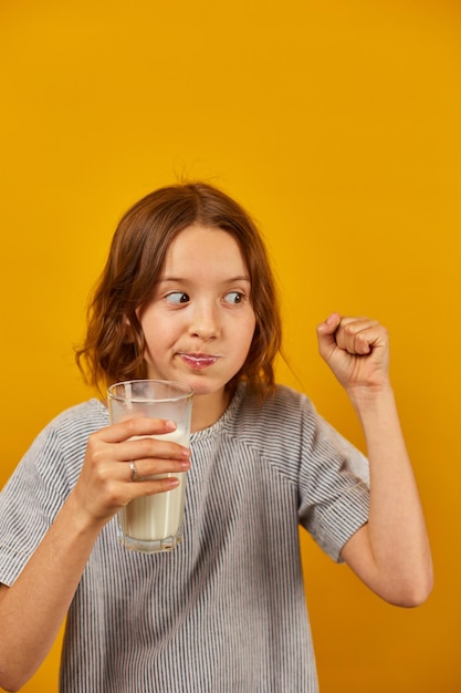 Pretty teen girl child with a fresh glass of milk