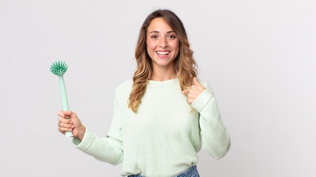 pretty thin woman feeling happy and pointing to self with an excited and holding a washing dish brush