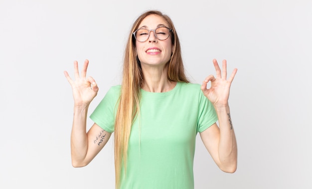 Pretty thin woman looking concentrated and meditating, feeling satisfied and relaxed, thinking or making a choice