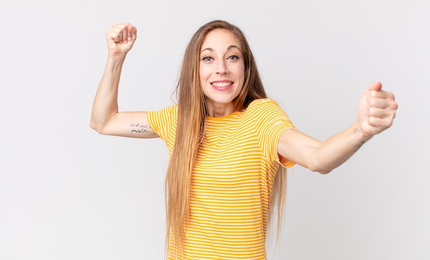 Pretty thin woman shouting triumphantly, looking like excited, happy and surprised winner, celebrating